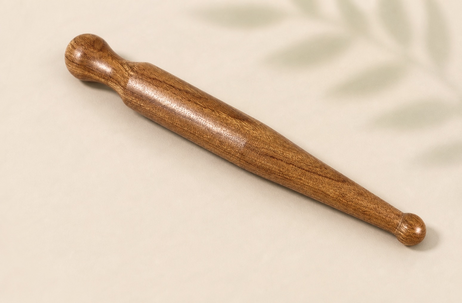 Natural sandalwood Acupressure Massage Stick on a warm neutral surface